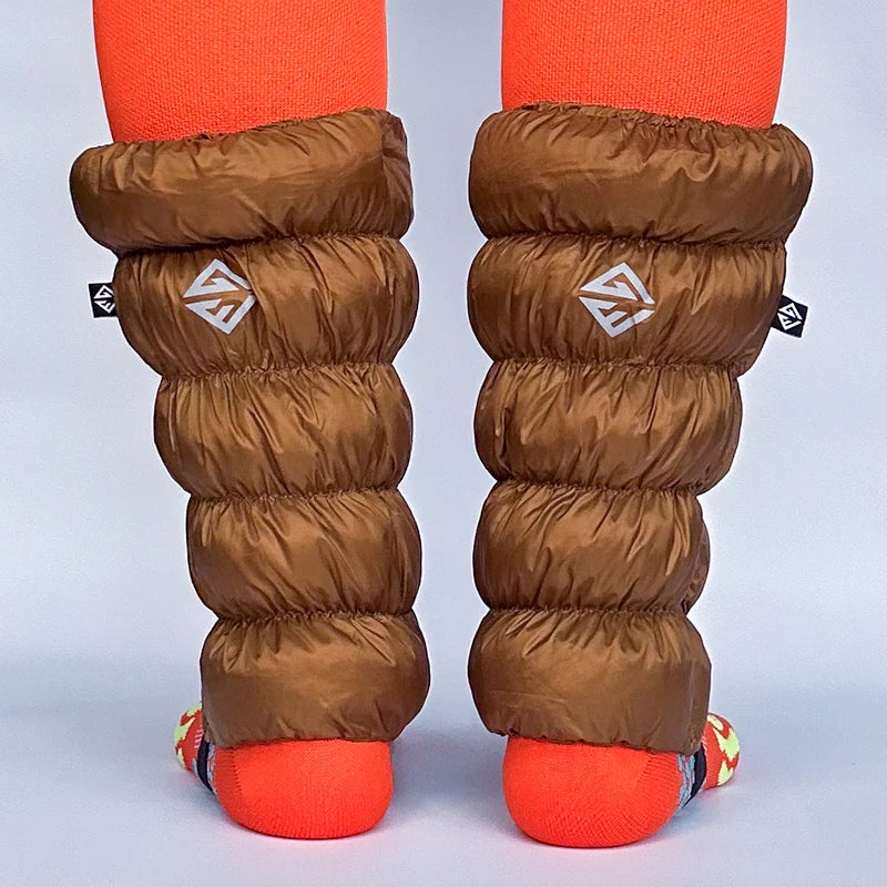 Back view of a model wearing light brown gaiters over orange socks against a white background. 