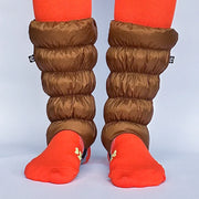 Front facing view of a model wearing orange socks and light brown gaiters over them against a white background. 