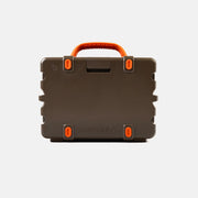 Brown hard-shell speaker with orange handles and accents on a light gray background