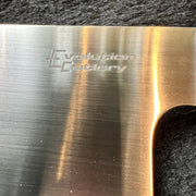 Close-up of a brushed stainless steel knife blade with the 'Evolution Cutlery' logo engraved on it, resting on a dark textured surface.