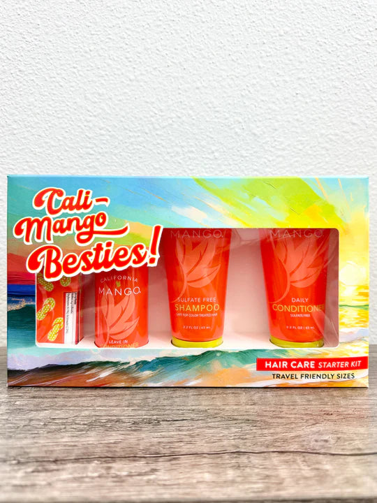 Cali-Mango Besties! Hair Care Starter Kit travel-friendly sizes, featuring a colorful tropical-themed box with three orange tubes of shampoo and conditioner and a small orange bottle, displayed on a wooden surface against a white wall.