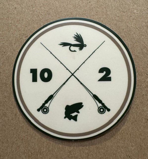 A circular white sticker featuring black crossed fishing rods, a fly lure, a fish silhouette, and the numbers 10 and 2