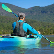 Person kayaking on a lake with mountains in the background