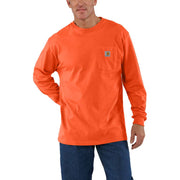 Man wearing a neon orange colored long sleeve shirt with a chest pocket against a white background. The chest pocket has a Carhartt logo on it. 