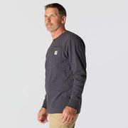 Side view of a man wearing a long sleeve carbon heather colored shirt against a white background. The shirt has a chest pocket with a Carhartt logo on it. 