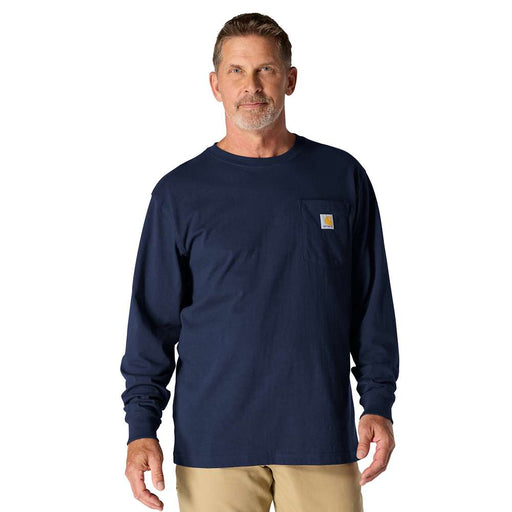 Man wearing a long sleeve navy colored shirt with a chest pocket against a white background. the chest pocket has a Carhartt logo on it.