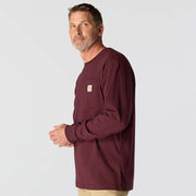 Side view of a man wearing a maroon colored long sleeve shirt with a chest pocket against a white background.
