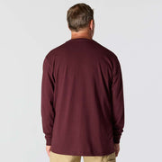 Man wearing a maroon long-sleeve shirt on a plain background