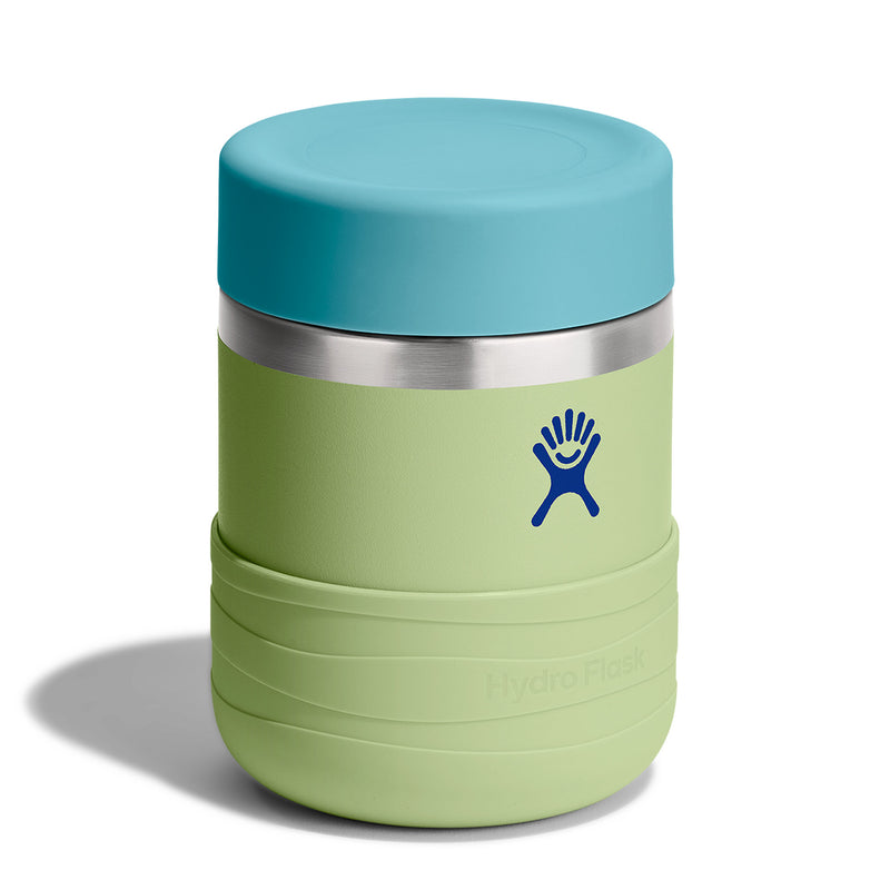 A Hydro Flask insulated travel tumbler in light green with a bright blue lid and a silver stainless steel band, shown on a white background with a soft shadow.