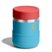 A Hydro Flask insulated tumbler with a bright blue body, a red lid, a stainless steel band, and a yellow logo on a white background.