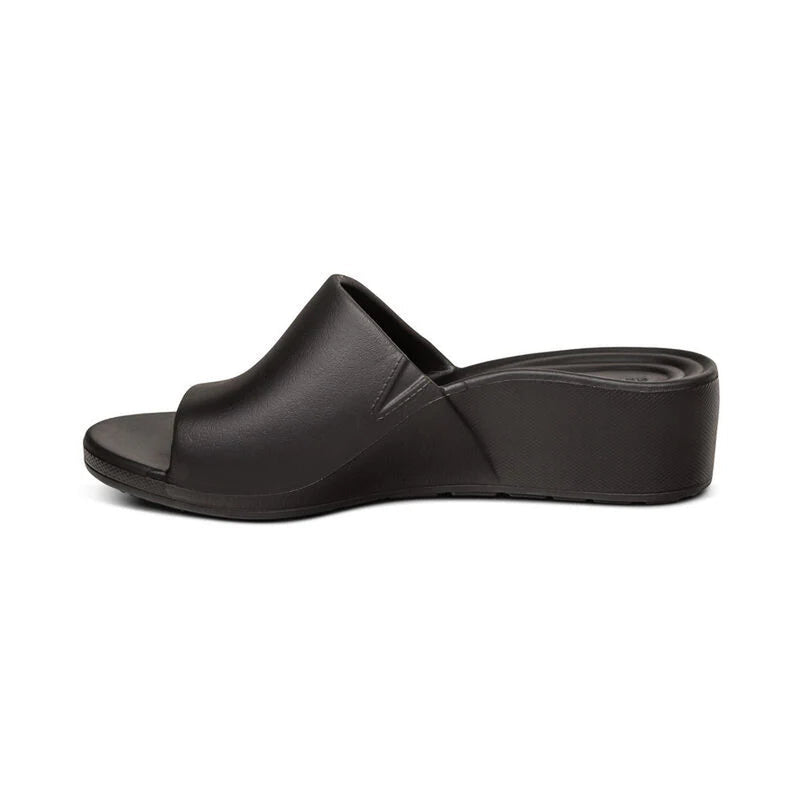 Side view of a black sandal against a white background. 