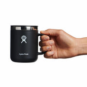 A black Hydro Flask 12oz mug with white logo held by a person's hand