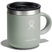 A Hydro Flask travel mug in sage green with a black lid, stainless steel rim, and white logo, shown on a white background with a soft shadow.