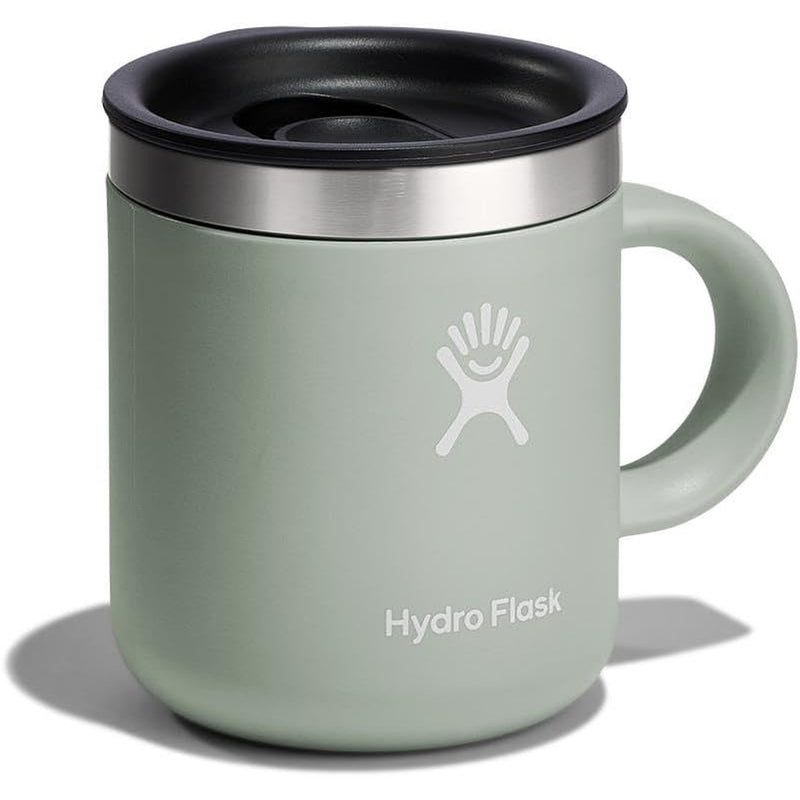 A Hydro Flask travel mug in sage green with a black lid, stainless steel rim, and white logo, shown on a white background with a soft shadow.