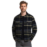 Man wearing a plaid shirt over a black t-shirt on a gray background