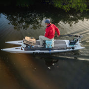 A man sailing with an extension rod connected to the motor with water in the background.
