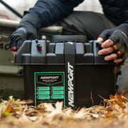 A person holding a battery box that has a visible Newport logo on it on the ground.