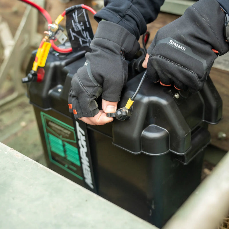 A person hooking a cable up to a battery box with a visible Newport logo on it.