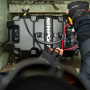 A person setting a battery box up on a green background.