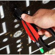 A close-up of a hand using an arrow puller and nock deactivating tool on a black background with white painted target markings.