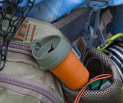 An orange container with a gray lid in a bag