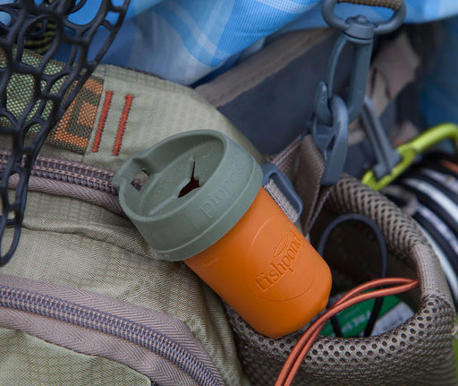An orange container with a gray lid in a bag