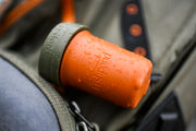 An orange container with a gray lid with water on it