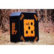 A black and orange Delta McKenzie target block standing outdoors on dry grass with trees in the background.