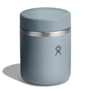 A dusty blue insulated can cooler with a stainless steel band and the Hydro Flask logo, shown on a white background with a soft shadow.