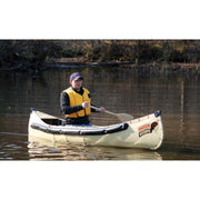 A man wearing a yellow life vest sits in a beige and black canoe on a body of water, holding a paddle. The canoe has a visible 'Plattner Discovery' logo on the front.