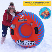 Child standing on a snowy mountain holding up a red inflatable tube with blue accents with a text that reads "ideal for snow or surf" showcasing it's versatility. 