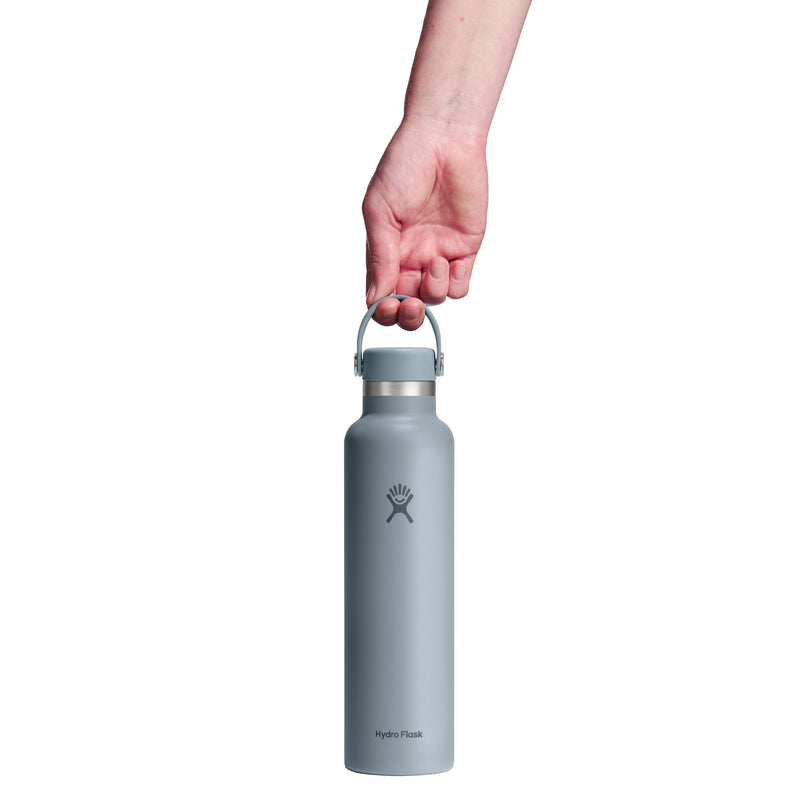 Person holding a light blue water bottle with a white background