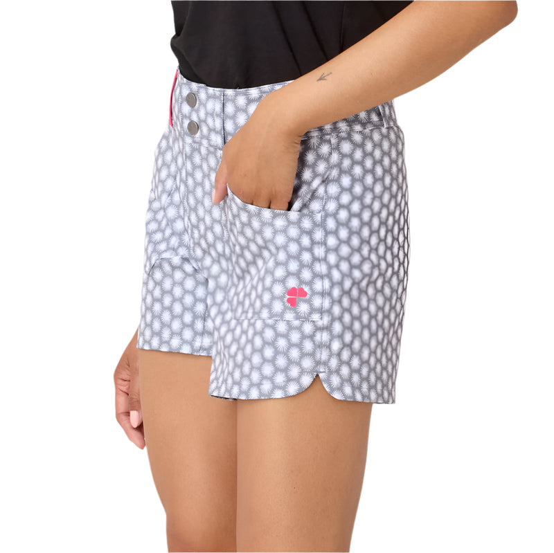 Person wearing a patterned pair of shorts with a visible brand logo on a plain background