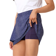 Person wearing a navy blue skirt with white polka dots on a light background