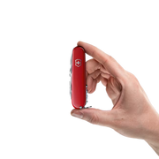 Hand holding a red colored multitool featuring a Victorinox logo against a white background. 