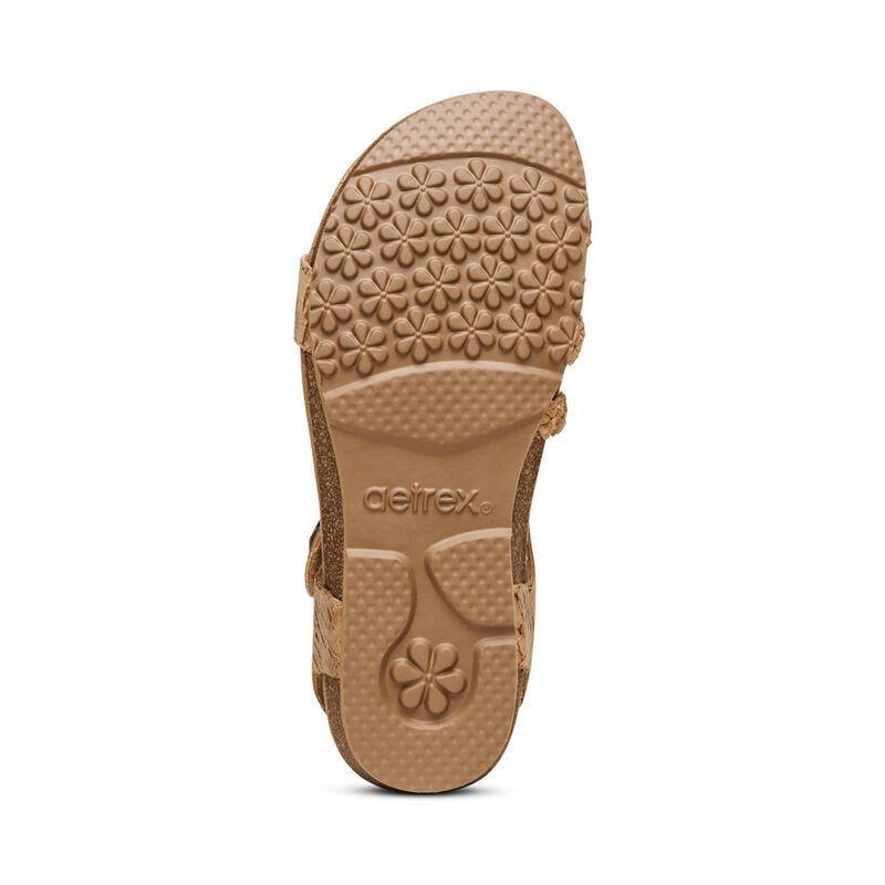 The bottom of a brown cork sandal on a white background