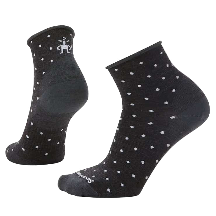 Black ankle socks with white polka dots on a light gray background