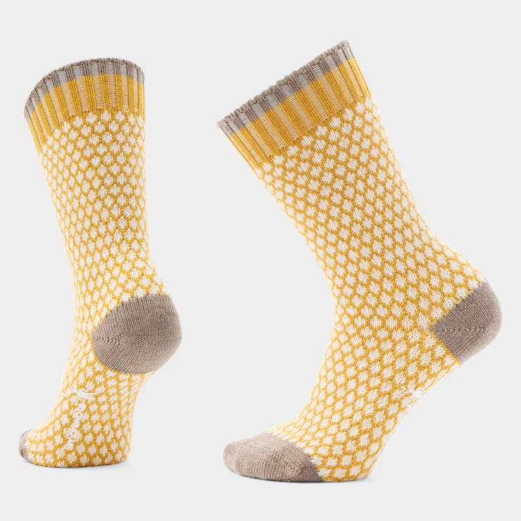 Yellow and white polka dotted crew socks on a white background.
