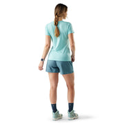 Woman wearing a light blue athletic outfit on a white background