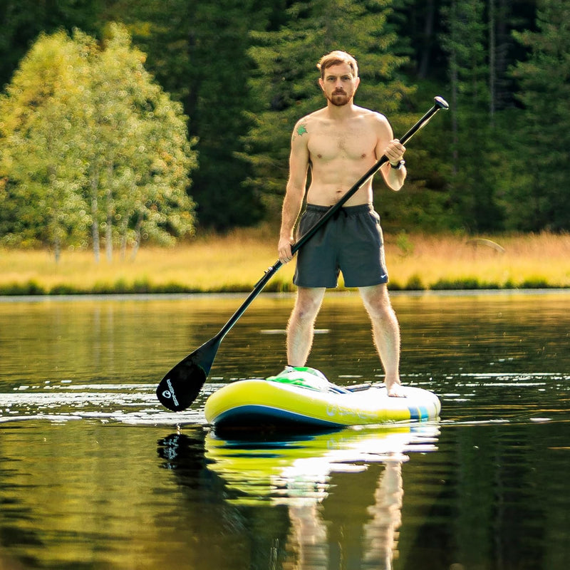 Man standing on a yellow and blue paddleboard in a lake. 