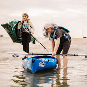 Two people with kayaks on a beach