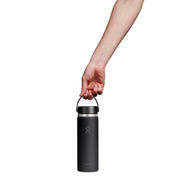 A hand holding the handle of a matte black insulated water bottle against a solid white background.