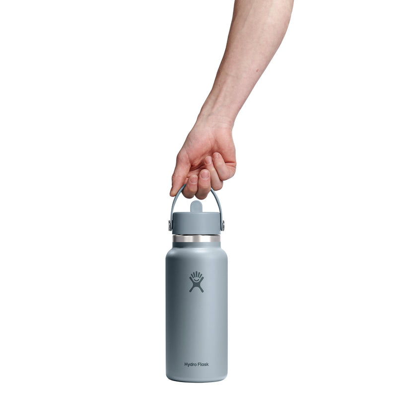 Hand holding a light blue Hydro Flask water bottle on a white background