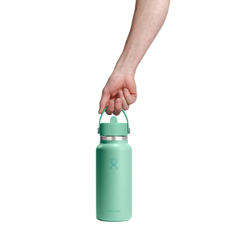 Person holding a mint green water bottle with a white background