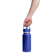Hand holding a blue water bottle with a white background