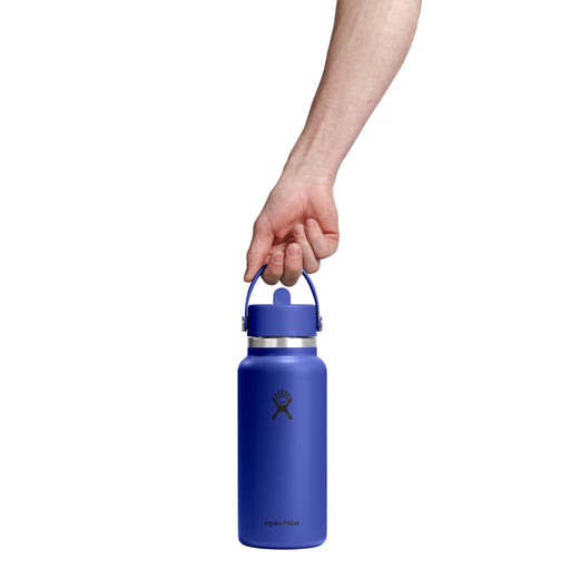 Hand holding a blue water bottle with a white background