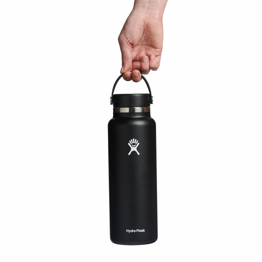 Black Hydro Flask water bottle held by a hand on a white background