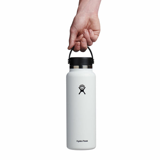 White Hydro Flask water bottle with a hand holding it on a white background