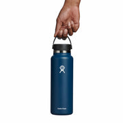 Blue Hydro Flask water bottle held by a hand on a white background