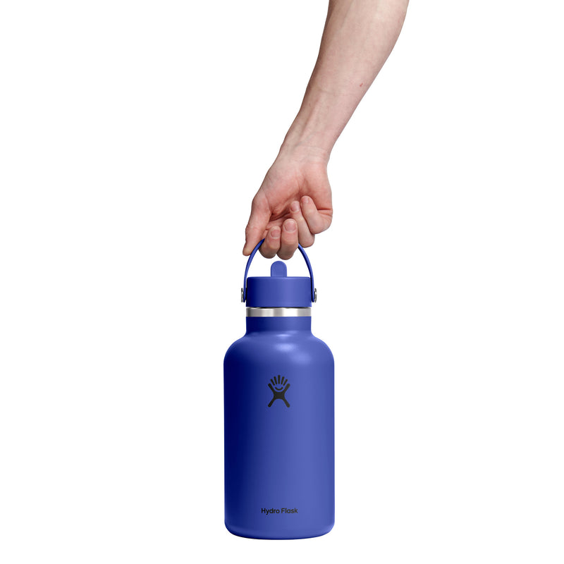Blue Hydro Flask water bottle held by a hand on a white background